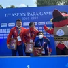 Kình ngư Võ Huỳnh Anh Khoa (giữa) xuất sắc giành huy chương Vàng đầu tiên cho đoàn thể thao người khuyết tật Việt Nam tại ASEAN Para Games lần thứ 11. (Ảnh: Chiến Phong/TTXVN)