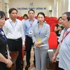 Bộ trưởng Bộ Giáo dục và Đào tạo Nguyễn Kim Sơn nghe báo cáo về công tác coi thi tại điểm thi Trường THPT Uông Bí, tỉnh Quảng Ninh. (Ảnh: Thanh Tùng/TTXVN)