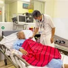 Bác sỹ Bệnh viện Quân y 175, Thành phố Hồ Chí Minh thăm khám cho các nạn nhân ngộ độc rượu sáng 15/7. (Ảnh: TTXVN phát)