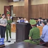 Bị cáo Phạm Thị Hằng, nguyên Giám đốc Sở giáo dục và đào tạo tỉnh Thanh Hóa được áp giải ra trước tòa. (Ảnh: TTXVN phát)