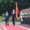 Thủ tướng Phạm Minh Chính và Thủ tướng Singapore Lý Hiển Long duyệt Đội Danh dự Quân đội Nhân dân Việt Nam. (Ảnh: Dương Giang/TTXVN)