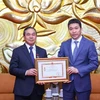 Chủ tịch Liên hiệp các Tổ chức Hữu nghị Việt Nam Phan Anh Sơn trao Kỷ niệm chương tặng Đại sứ Lào tại Việt Nam Sengphet Houngboungnuang. (Ảnh: Văn Điệp/TTXVN)