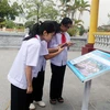 Học sinh quét mã QR để tìm hiểu thân thế, sự nghiệp nhà văn Nam Cao tại khu lưu niệm. (Ảnh: Nguyễn Chinh/TTXVN)