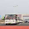 Các xe trung chuyển (xe điện) chở khách du lịch xuất cảnh đi qua vạch phân quảng cầu Bắc Luân II. (Ảnh: Thanh Vân/TTXVN)