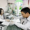 Khách hàng giao dịch tại Vietcombank Hà Nội. (Ảnh: Trần Việt/TTXVN)