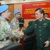 Thượng tướng Hoàng Xuân Chiến chúc mừng các sỹ quan tại lễ trao Quyết định. (Ảnh: Trọng Đức/TTXVN)