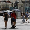 Người dân di chuyển dưới trời nắng nóng tại Madrid, Tây Ban Nha, ngày 9/8/2023. (Ảnh: AFP/TTXVN)