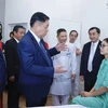 Trưởng Ban Tuyên giáo Trung ương Nguyễn Trọng Nghĩa thăm hỏi, tặng quà cho bệnh nhân đang điều trị tại Bệnh viện Thể thao Việt Nam. (Ảnh: Minh Quyết/TTXVN)