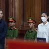 Hai bị cáo Trần Văn Sỹ (trái) và bị cáo Đặng Thị Hàn Ni (phải) đứng nghe tuyên án. (Ảnh: Hồng Giang/TTXVN)