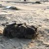 Túi màu đen chứa 20 bánh tinh thể màu trắng nghi ma túy trên bờ biển được phát hiện vào sáng nay 6/3. (Ảnh TTXVN phát)