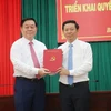 Trưởng Ban Tuyên giáo Trung ương Nguyễn Trọng Nghĩa (trái) trao Quyết định cho đồng chí Trần Thanh Lâm. (Ảnh: Chương Đài/TTXVN)