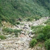 Thượng nguồn suối Lương trên đèo Hải Vân bị cạn trơ đáy, nhìn từ xa chỉ thấy đất đá. (Ảnh: Quốc Dũng/TTXVN)