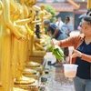 Trong quan niệm của người Lào việc tắm Phật chính là tỏ lòng tôn trọng, là cách thức bày tỏ đức tin của mình với Đức Phật. (Ảnh: Đỗ Bá Thành/TTXVN)