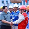 Thủ tướng Phạm Minh Chính với công nhân thi công dự án. (Ảnh: Dương Giang/TTXVN)