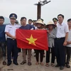 Hải đội 102 - Bộ Tư lệnh vùng Cảnh sát biển 1 trao tặng cờ Tổ quốc cho ngư dân Cẩm Nhượng, huyện Cẩm Xuyên. (Ảnh: Hoàng Ngà/TTXVN)
