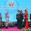 Thượng tướng Hoàng Xuân Chiến, Thứ trưởng Bộ Quốc phòng gắn Huân chương Bảo vệ Tổ quốc hạng Ba lên cờ của Đội Công binh số 1. (Ảnh: Trọng Đức/TTXVN)