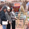 Du khách tham quan khu trưng bày ảnh về văn hóa Bắc Ninh tại Trung tâm Bảo tồn tranh dân gian Đông Hồ, thị xã Thuận Thành. (Ảnh: Thanh Thương/TTXVN)