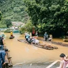 Tuyến đường thuộc thị trấn Pác Mjầu, huyện Bảo Lâm bị ngập sâu, người dân phải dùng bè mảng để di chuyển. (Ảnh: Bảo Chung/TTXVN phát)