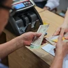 Người dân nhận tiền tại điểm chi trả Nhà văn hoá khu dân cư số 3A - 3B Thanh Lương, quận Hai Bà Trưng, Hà Nội (ngày 6/5/2024). (Ảnh: Hoàng Hiếu/TTXVN)