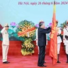 Chủ tịch nước Tô Lâm gắn Huân chương Chiến công hạng Nhì lên cờ truyền thống của Lực lượng kỹ thuật nghiệp vụ Công an Nhân dân. (Ảnh: Nhan Sáng/TTXVN)
