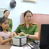 Cán bộ chiến sỹ Đội cảnh sát quản lý hành chánh về trật tự xã hội Công an Quận 10 Thành phố Hồ Chí Minh thực hiện cấp thẻ căn cước, tài khoản định danh điện tử cho trẻ em tại địa phương. (Ảnh: Thanh Vũ/TTXVN)