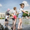 Các em nhỏ tránh nóng bên đài phun nước tại Moskva, Nga. (Ảnh: Getty Images/ TTXVN)