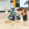 Bộ đội hỗ trợ người dân di chuyển qua khu vực ngập lụt tại thành phố Sơn La. (Ảnh: Quang Quyết/TTXVN)