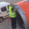 Nhân viên sân bay dùng băng dính để dán lên mép nối trên vỏ tuabin trước khi máy bay cất cánh. (Nguồn: Daily Mail)
