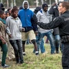 Cảnh sát cố gắng ngăn cản những người di cư tiếp cận đường đường ray tại Coquelles gần Calais. (Nguồn: AFP)