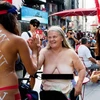 Bà Claire Hogenauer, 69 tuổi, cùng hai cô gái trẻ để ngực trần tại quảng trường Thời Đại. (Nguồn: nydailynews)