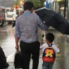 Bức ảnh người cha che ô cho con gây sốt cộng đồng mạng. (Nguồn: CCTV News)