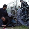 Người tị nạn Syria tìm mọi cách chui qua hàng rào ở biên giới. (Nguồn: AP)
