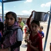 Trẻ em Iraq xếp hàng nhận lương thực cứu trợ tại khu vực Dora, ngoại ô thủ đô Baghdad ngày 31/5. (Nguồn: AFP/TTXVN)