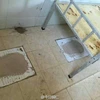 Bệ xí trong nhà vệ sinh được trát ximăng để tạo nền phẳng cho phòng ngủ giường tầng cho học sinh. (Nguồn: CCTV)