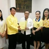 Tiến sỹ Boonlue Chaimano, Chủ nhiệm bộ môn tiếng Thái thuộc Đại học Lampang Rajabhat tặng sách cho Hiệu trưởng Đại học Lampang Rajabhat Somkiat Saithanoo. (Ảnh: Ngọc Quang/TTXVN)