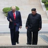 Tổng thống Mỹ Donald Trump (trái) và nhà lãnh đạo Triều Tiên Kim Jong-un (phải) bất ngờ gặp lại nhau tại DMZ hôm 30/6. (Ảnh: THX/TTXVN)