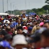 Người di cư trong hành trình tới Mỹ tại cây cầu biên giới Guatemala-Mexico. (Ảnh: AFP/ TTXVN)