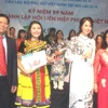 Hai thí sinh (đứng giữa) đoạt giải cao nhất cuộc thi. (Ảnh: Hoàng Nhương/Vietnam+)