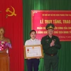 Vợ thiếu tá Vi Văn Nhất đón nhận Huân chương Chiến công hạng Nhất. (Ảnh: Trịnh Duy Hưng- TTXVN)