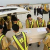 Nhân viên sân bay quốc tế Nội Bài vận chuyển thi thể các nạn nhân lên ô tô để đưa về quê nhà. (Ảnh: Lâm Khánh/TTXVN)