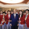 Thủ tướng Nguyễn Xuân Phúc chụp ảnh chung với các tuyển thủ bóng đá nữ quốc gia. (Ảnh: Thống Nhất/TTXVN)
