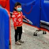 Bé gái đeo khẩu trang phòng nguy cơ dính virus corona. (Nguồn: Reuters)