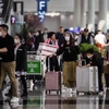 Hành khách đeo khẩu trang để phòng tránh lây nhiễm virus corona tại sân bay quốc tế Hong Kong. (Ảnh: AFP/TTXVN)