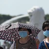 Người dân đeo khẩu trang để phòng tránh lây nhiễm virus corona tại Singapore. (Ảnh: AFP/TTXVN)