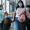 Hành khách đeo khẩu trang đề phòng lây nhiễm virus corona tại sân bay quốc tế Changi, Singapore. (Ảnh: AFP/TTXVN)