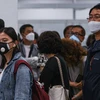 Hành khách đeo khẩu trang phòng lây nhiễm virus corona tại sân bay Kuala Lumpur, Malaysia. (Ảnh: AFP/TTXVN)