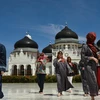 Khách du lịch nước ngoài thăm nhà thờ Hồi giáo Baiturrahman ở Banda Aceh, Indonesia. (Ảnh: AFP/TTXVN)