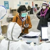 Nhân viên y tế tiếp nhận bệnh nhân tại một bệnh viện ở Vũ Hán, Trung Quốc. (Ảnh: THX/TTXVN)