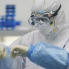 Kỹ thuật viên xử lý mẫu xét nghiệm axit nucleic tại một phòng thí nghiệm về virus SAR-CoV-2 ở Vũ Hán, Trung Quốc. (Ảnh: THX/TTXVN)