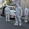 Nhân viên y tế Hàn Quốc làm nhiệm vụ tại một khu dân cư ở thành phố Daegu, nơi phát hiện các trường hợp có triệu trứng nhiễm virus SARS-CoV-2, ngày 27/2. (Ảnh: AFP/TTXVN)